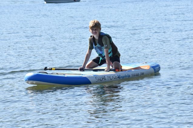 Boy kneeling on paddle board